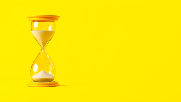 yellow hourglass against a bright yellow background photo