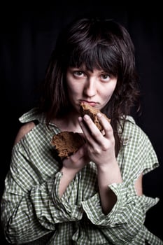 Poor beggar woman with a piece of bread. photo