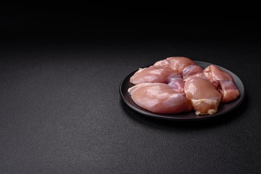 Fresh raw chicken thigh fillets with salt, spices and herbs photo
