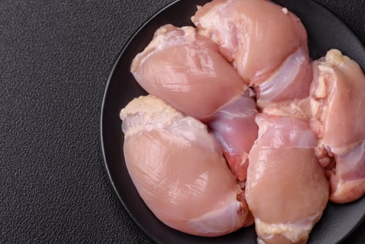 Fresh raw chicken thigh fillets with salt, spices and herbs photo