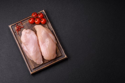 Pieces of raw chicken or turkey fillet with salt, spices and herbs photo