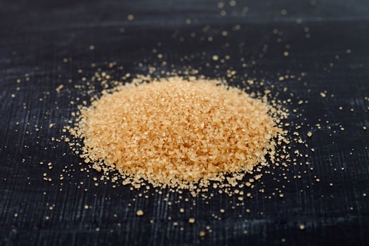 Brown cane sugar heap on black board. photo