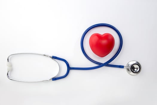 Red decorative heart and stethoscope isolated on white background photo