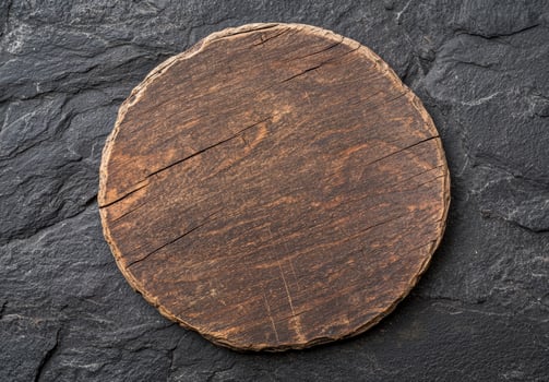 Rustic wooden cutting board on dark slate background photo