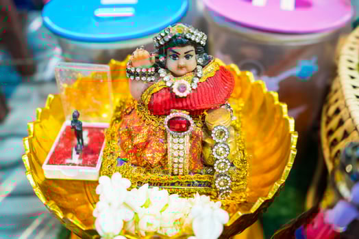 Nonthaburi, Thailand - July, 11, 2024 - Charming Nang Kwak Statue in a Gold Tray at a Local Market Eatery at Nonthaburi, Thailand photo
