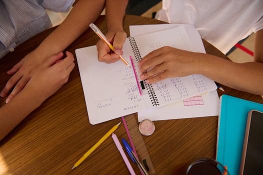 Students collaborate on math homework at wooden desk photo