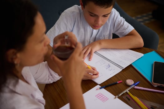 Young student doing homework with guidance from adult photo