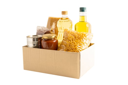 Foodstuff for donation isolated on white background with clipping path, storage and delivery. Various food, pasta, cooking oil and canned food in cardboard box. photo