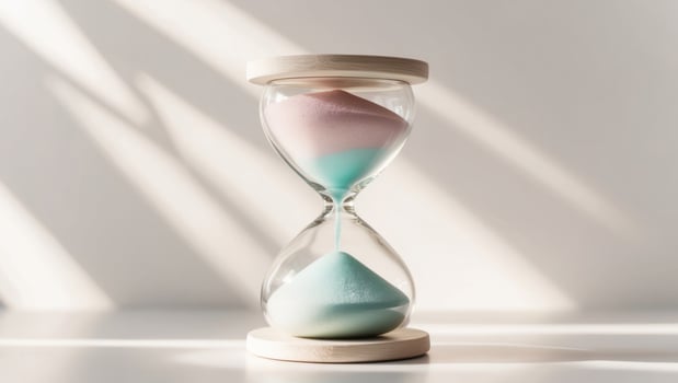 An hourglass with pink and blue sand photo