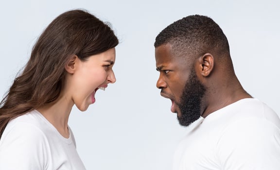Interracial couples problems. Young man and woman yelling at each other, arguing, having relationship crisis, posing over light background, side view photo