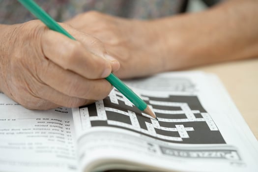 elderly woman playing sudoku puzzle game. photo