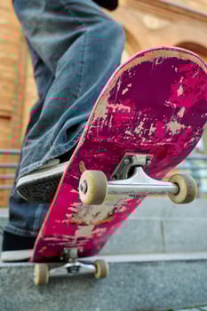 Close-up of skateboarder on pink skateboard at street photo