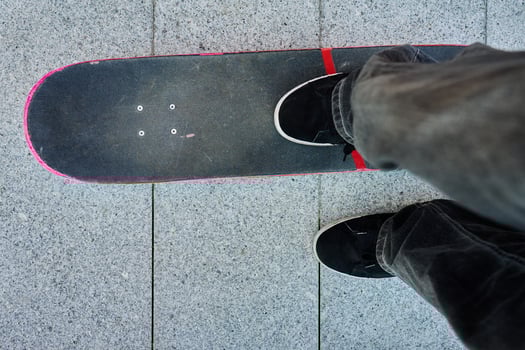 Top view of skateboarder riding on skateboard on road photo