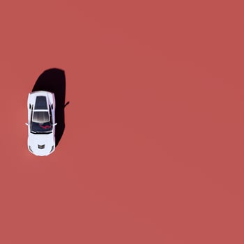 An overhead view of a white car on a red background photo