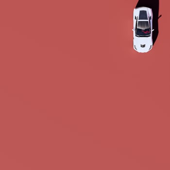 A white car is sitting on top of a red surface photo