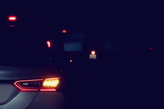 Abstract of rear side car on the road at night. Stop and turn on the right turn signal. Cars drive through a crosswalk at night. photo