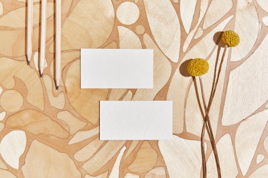 Stylish flat lay creative composition with mock up visit cards, pencil, wood, natural materials, dry plants and personal accessories. Neutral colors, top view, template. photo