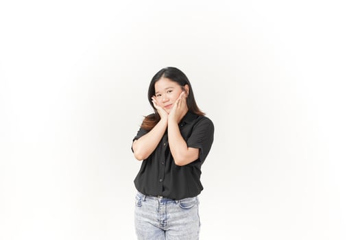 beautiful Asian woman gently holds her cheeks with both palms, showcasing a soft expression against a white background photo