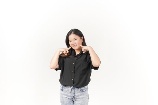 beautiful Asian woman points to her cheek with her index finger, highlighting her facial expression against a white background photo