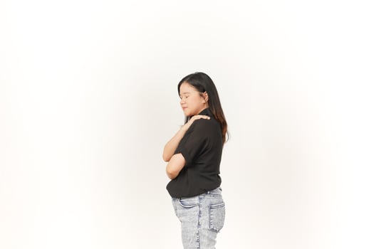beautiful Asian woman places her hand gently on her chest, expressing sincerity or gratitude, against a white background photo