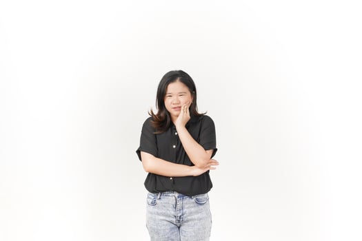 beautiful Asian woman poses with a pained expression, holding her cheek in discomfort due to a toothache against a white background photo