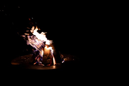 Campfire with Dancing Flames and Sparks Against Dark Background photo