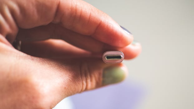A hand holding usb plug c type close up minimalist technology photo