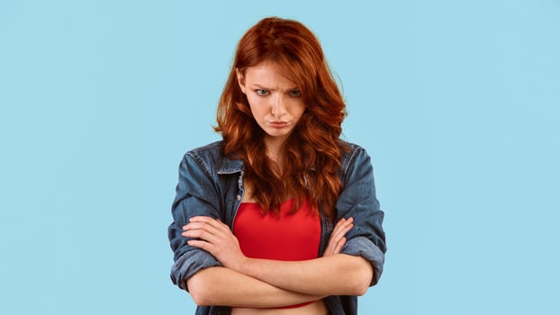 Sulky Teen Girl Crossing Hands Looking At Camera Posing Over Yellow Studio Background. Panorama photo