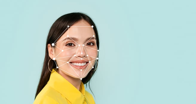 A woman smiles while a facial recognition technology overlay maps her features. This modern technology sets a contemporary tone against the light blue background. photo