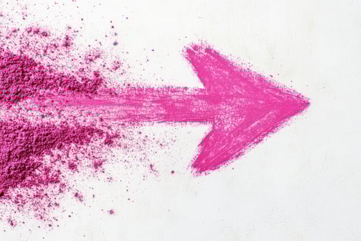 Vibrant pink arrow created with powder paint on a clean white background representing creativity and boldness photo