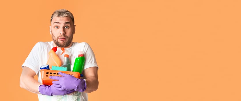 Cleanliness at home concept. Funny man with basket of cleaning supplies photo