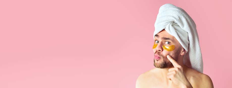 Funny guy with towel on head looks in mirror at patches for eyes photo
