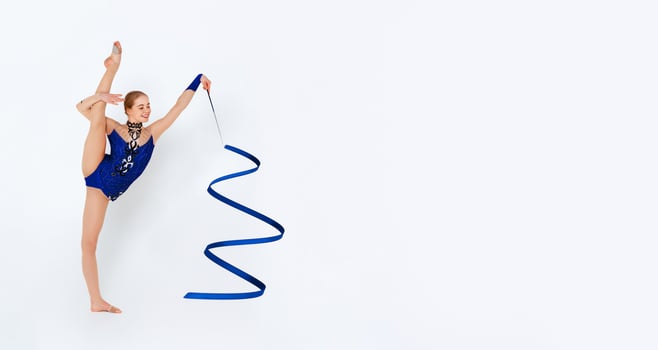 Gymnastics athlete performing beautiful dance with ribbon on white background photo