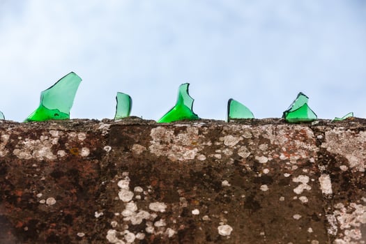 Cement wall covered with broken glass photo