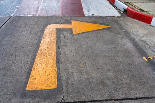 Yellow Arrow on Concrete Surface - Symbolizing Direction photo