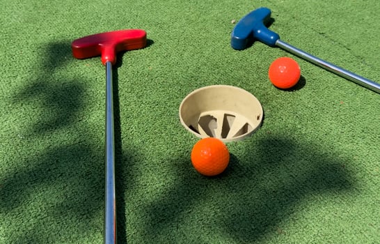 Closeup of player play mini golf with ball photo