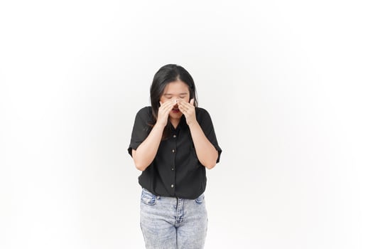 beautiful Asian woman appears to sneeze, displaying allergy symptoms with a hand covering her nose, set against a white background photo