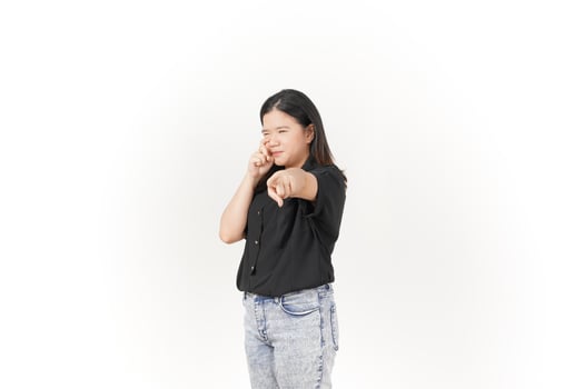 beautiful Asian woman poses with her fingers under her eyes, capturing a poignant crying expression against a white background photo