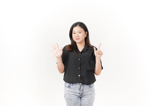beautiful Asian woman poses with her hands to display the number seven against a clean white background photo