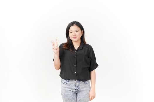 beautiful Asian woman poses, displaying the number three with her fingers against a white background photo
