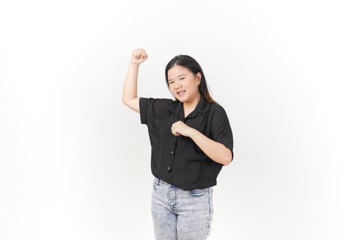 beautiful Asian woman strikes a joyful pose, raising her hands high in celebration against a white background photo