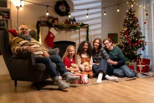 Grandfather, parents, and the teenage girls are relaxing in the living room at home on Christmas night photo