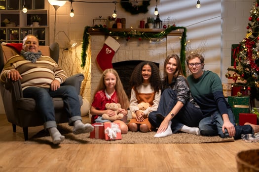 Grandfather, parents, and the teenage girls are relaxing in the living room at home on Christmas night photo