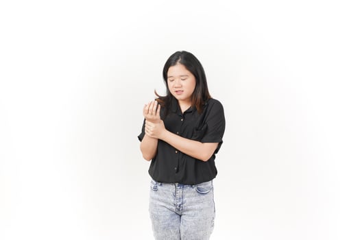 beautiful Asian woman holds her sore palm, expressing discomfort against a clean white background photo