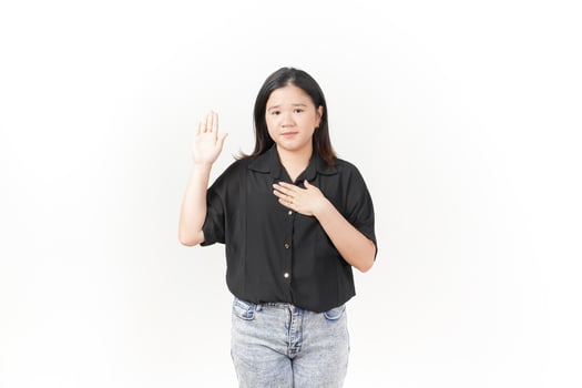 beautiful Asian woman stands confidently, holding her chest with one hand raised against a white background photo