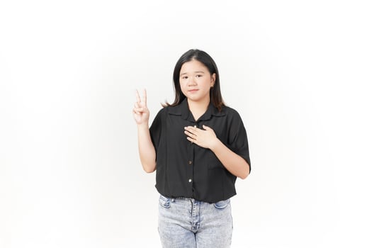 beautiful Asian woman stands confidently, holding her chest with one hand raised against a white background photo