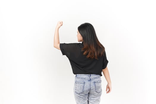 beautiful Asian woman strikes a bodybuilding pose, raising her arms confidently against a white background photo