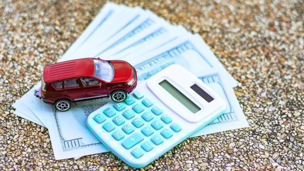 Model car and calculator are on euro banknotes with blur background. Planning of saving for buying car, car loan and car insurance concept. photo