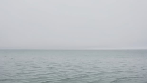 A boat is in the water on a foggy day photo