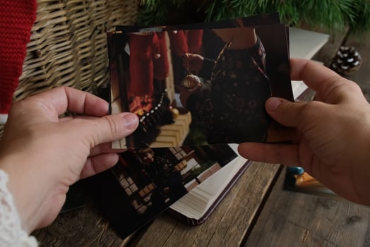 Hands Holding Printed Christmas Photos for Family Photo Album